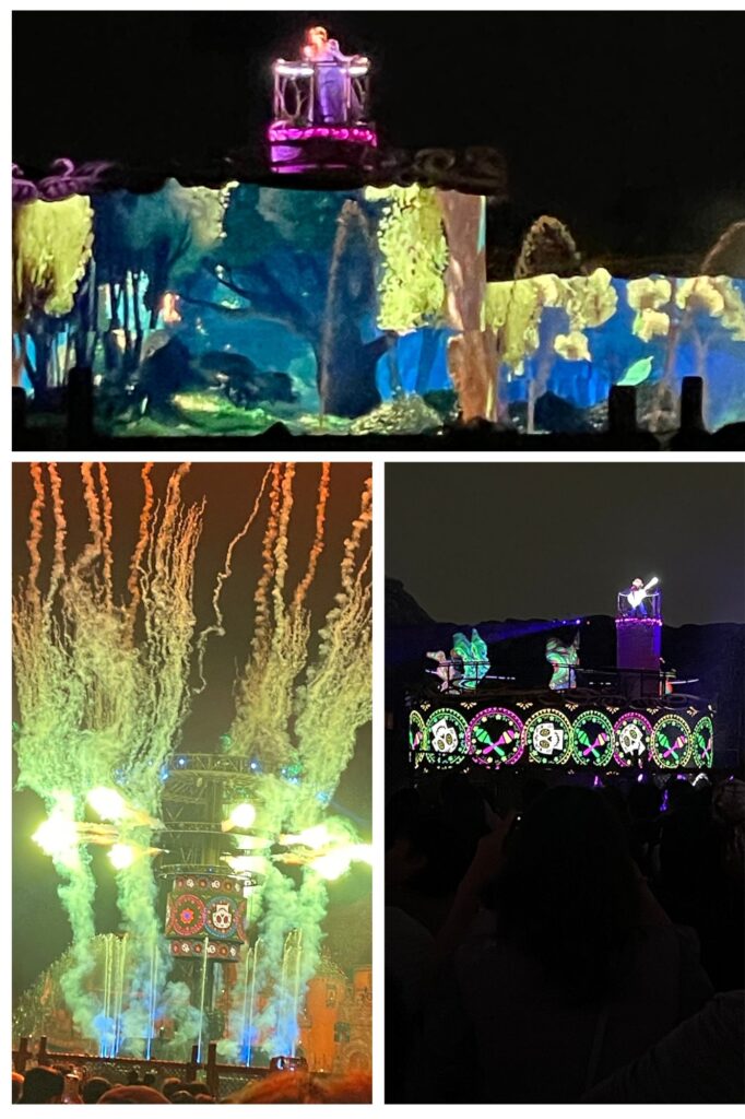 ディズニーシーの夜のショーで、色とりどりのプロジェクションマッピングと花火が舞い上がる様子。中央にキャラクターが立ち、周囲には華やかな光の演出が施されている。