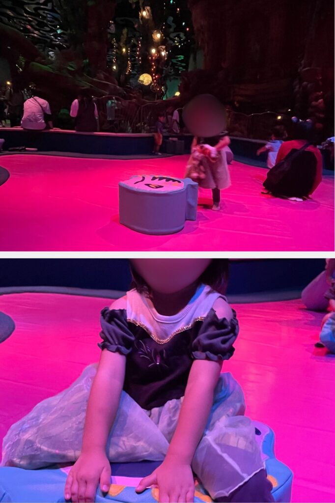 A child dressed in a princess costume playing in a colorful indoor play area with soft seating and ambient lighting.